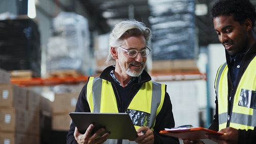 Two warehouse workers scanning SKU's into a warehouse management system using a barcode scanner