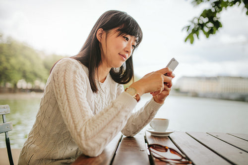 Beautiful asian woman using mobile phone at cafe