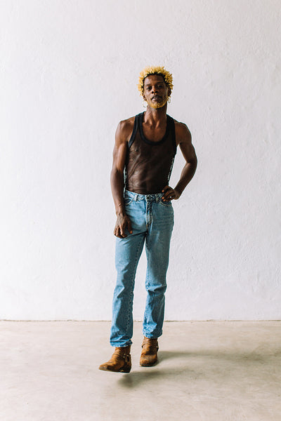 Confident gay man standing against a white background