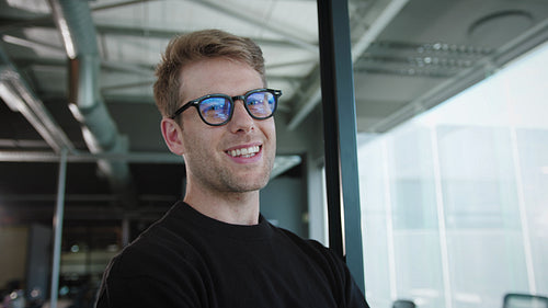 Business man standing in an office and smiling at the camera