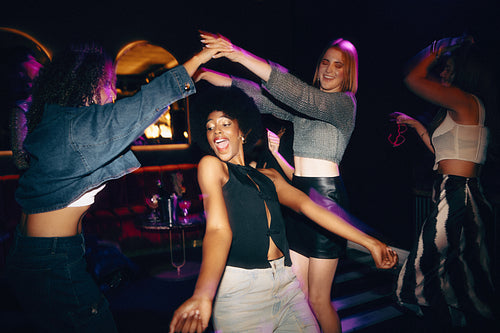 Group of friends dancing together in a lively nightclub setting