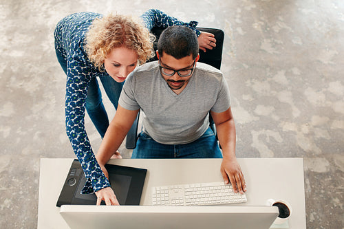 Two young designers working on a pc