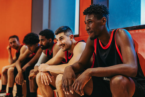Basketball team resting on bench during break in indoor sports court
