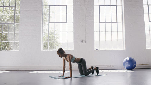 Woman doing downward facing dog in yoga studio