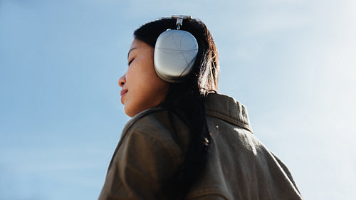 Woman listening to music with headphones outdoors
