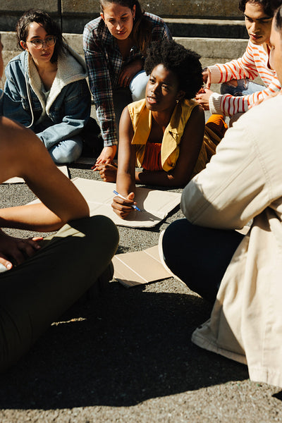 Diverse group of young people gathered in discussion during outdoor activism event