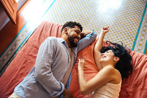 Smiling couple lying together on a bed during a relaxed morning