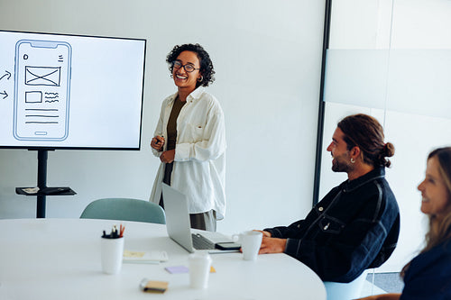 Woman presenter leads UX design briefing for team