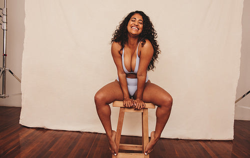 Self-confident young woman laughing while wearing blue underwear