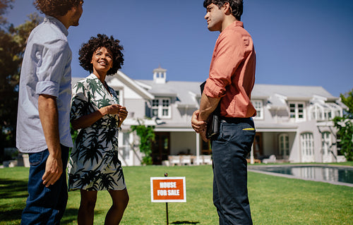 Real estate agent presenting modern house to a couple