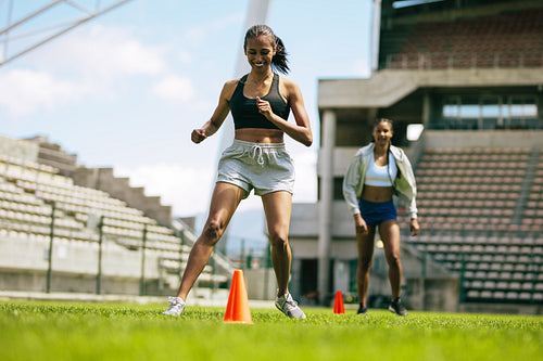 Female footballers improving agility with running drills