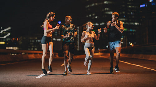 Runners training together outdoors in evening
