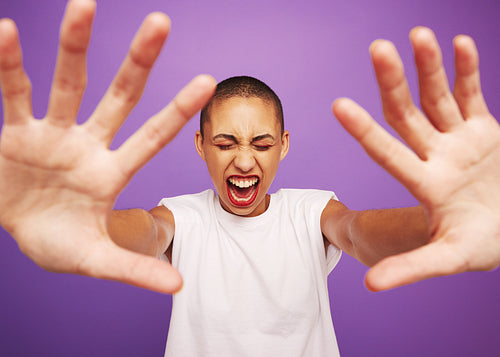 Excited woman screaming on purple background