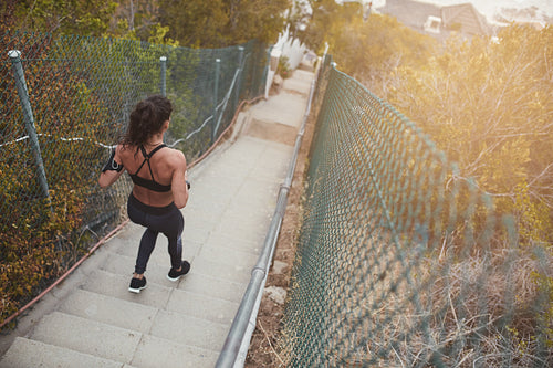 Fitness young woman running down the steps