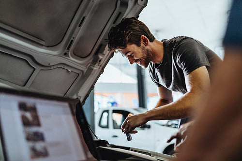 Young mechanic fixing a car