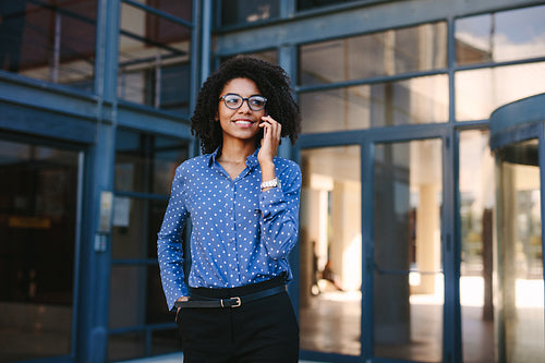 Business professional making a phone call outside office building