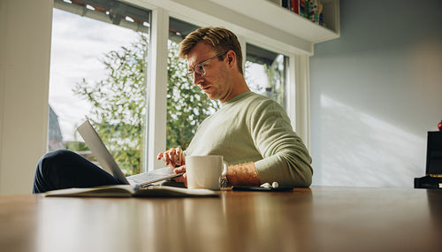 Man at home using laptop