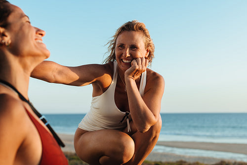 Mature women enjoying friendship and relaxation at the seaside in evening light