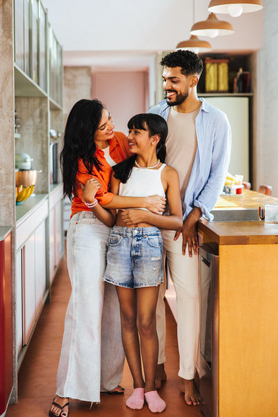 Happy Latino family standing together in a modern kitchen with joy