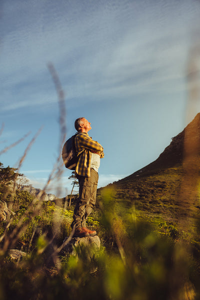 Hiker standing on a hill looking at the hills around