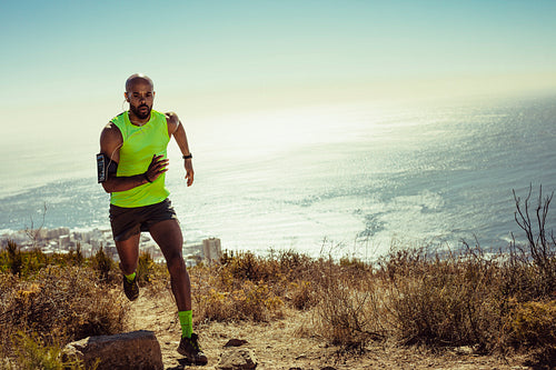 Fitness man running over mountain trail