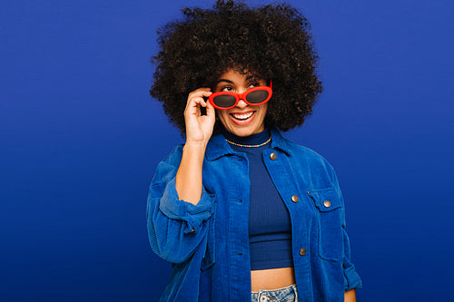 Fashionable young woman wearing sunglasses in a studio