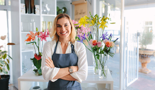 Beautiful woman florist standing in flower shop