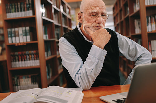 Senior man studying in library