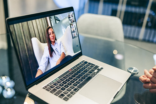 Unrecognizable businesswoman attending a video conference in an office