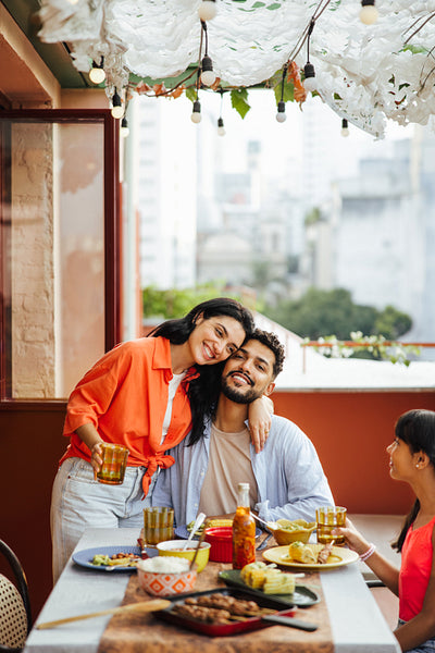 Happy Latin American family enjoying a meal together on a festive balcony setting