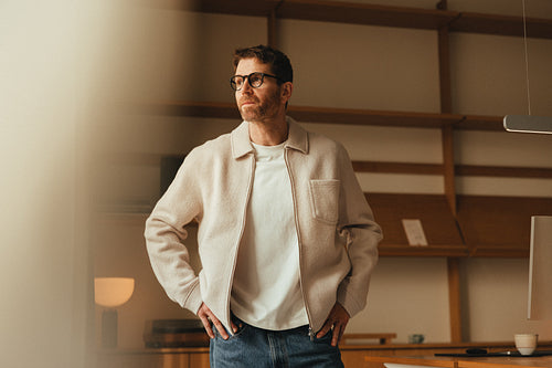 Man stands thoughtfully in a contemporary office