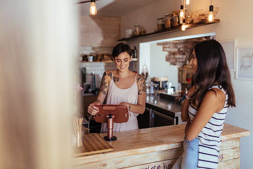 Woman entrepreneur taking orders at her restaurant