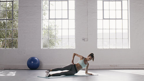 Woman doing side planks workout at fitness studio