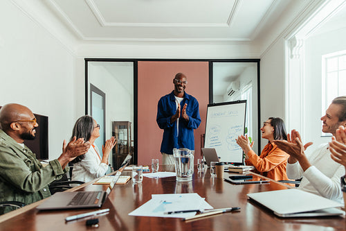 Team celebrating success during a presentation in a modern office boardroom