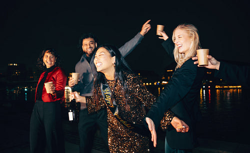 Group of friends enjoying a festive night by the city waterfront