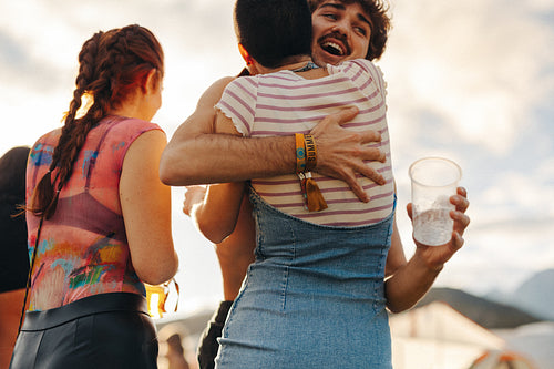Friends hugging upon meeting at a fun summer festival