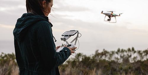 Woman in countryside flying drone and taking pictures