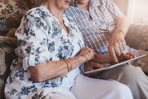 Senior couple sitting together using touch screen computer