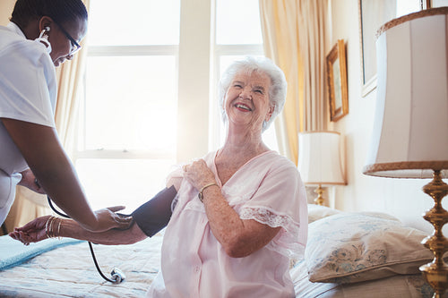 Doctor checking blood pressure of a senior woman