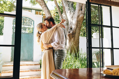 Married couple kissing outside a hotel entrance