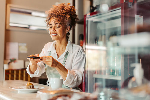 Cafe owner taking a picture of her food