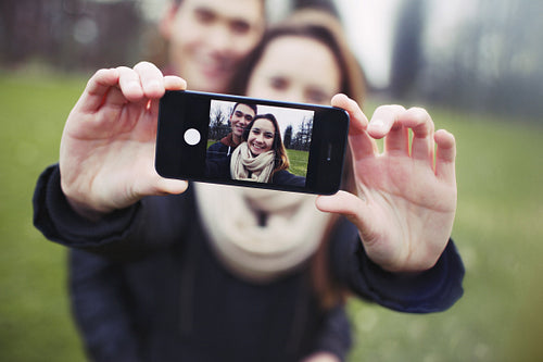 Affectionate young couple taking a self-portrait with smartphone