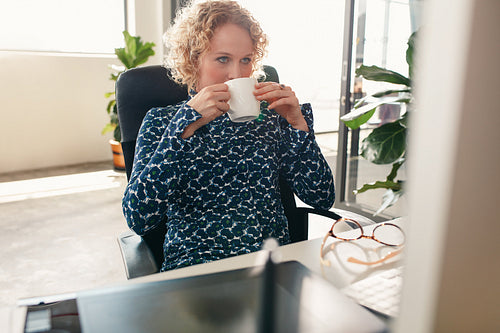 Thoughtful designer having coffee in office