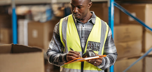 Warehouse worker recording inventory in a logistics centre
