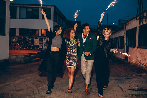 Friends walking down the city street with firework