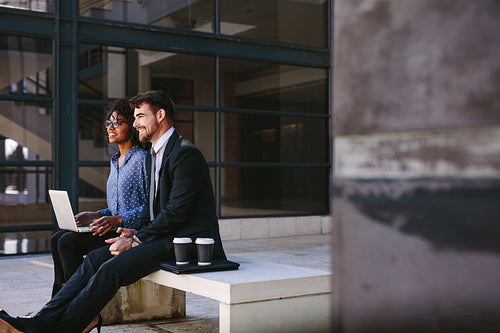 Business colleagues sitting at office hallway