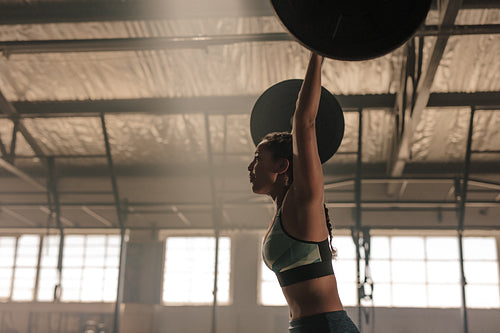 Woman exercising heavy weights at gym