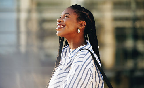 Happy young businesswoman smiling while standing outdoors in the city