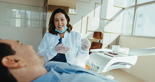Female dentist consults with male patient about aligner treatment