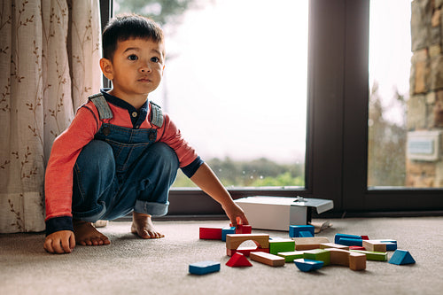 Innocent little kid with toys on floor